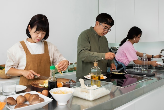 Foto zijaanzicht aziatische familie samen koken