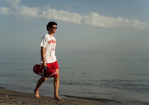 Zijaanzicht badmeester wandelen op het strand