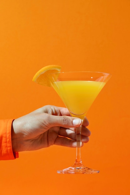 Zijaanzicht hand met mimosa cocktail