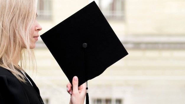 Zijaanzicht jonge vrouw die haar afstuderen viert