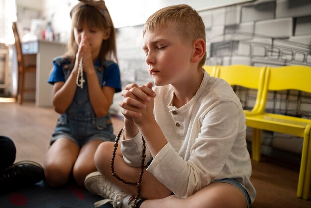 Foto zijaanzicht kinderen bidden op zondagsschool