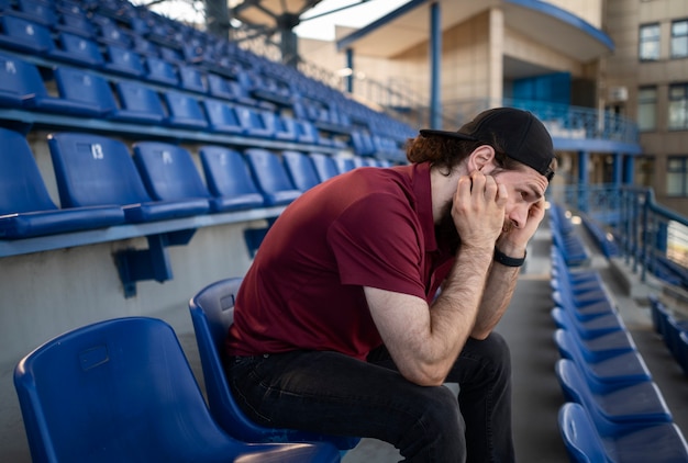 Foto zijaanzicht man zit op tribune