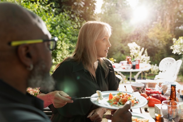 Foto zijaanzicht mensen met eten in de natuur