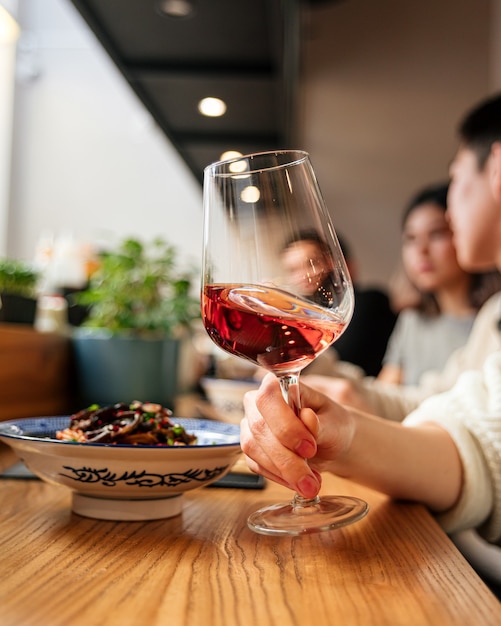 Zijaanzicht op hand met een glas wijn aperolecocktail