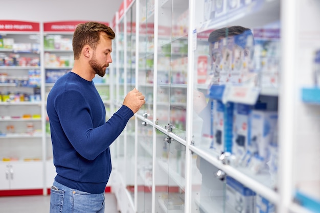 Zijaanzicht op knappe zieke man die pillen kiest