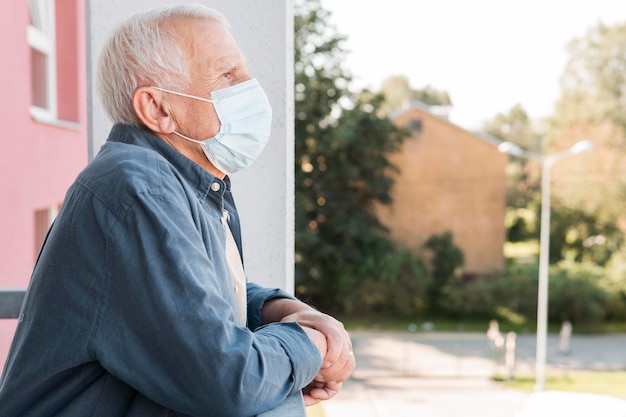 Zijaanzicht oude man met medische masker