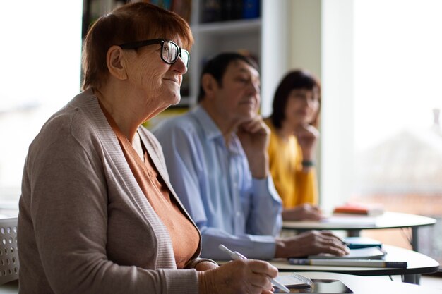 Foto zijaanzicht senior mensen die samen leren