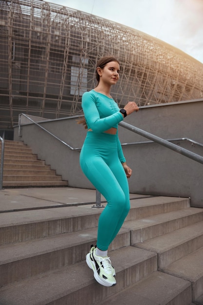 Foto zijaanzicht shot van fitness vrouw die op trappen loopt vrouwelijke atleet die de trap afgaat