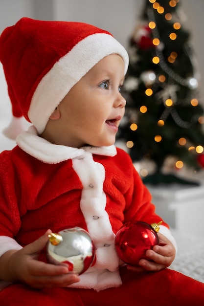 Foto zijaanzicht smiley baby met kerst outfit