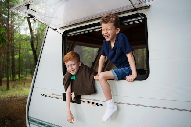 Foto zijaanzicht smiley kinderen in camper