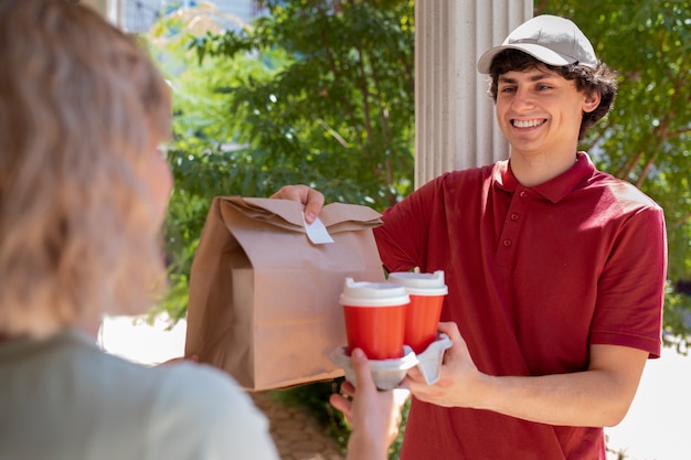 Foto zijaanzicht smiley man die koffie levert