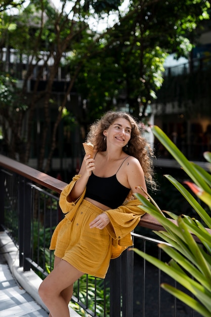 Foto zijaanzicht smiley vrouw met ijs buitenshuis