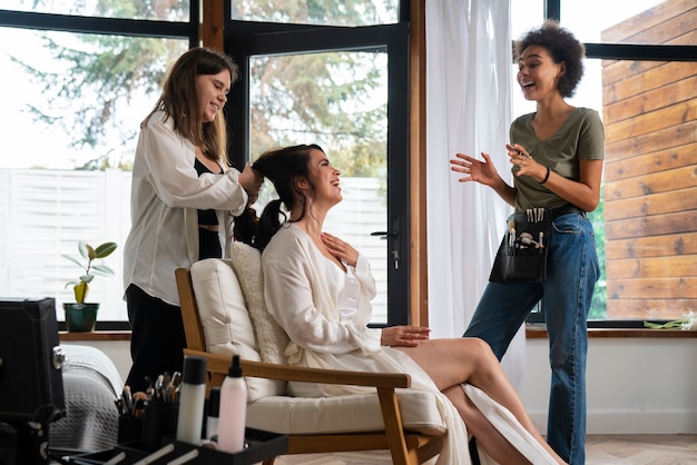 Foto zijaanzicht smiley vrouwen helpen bruid