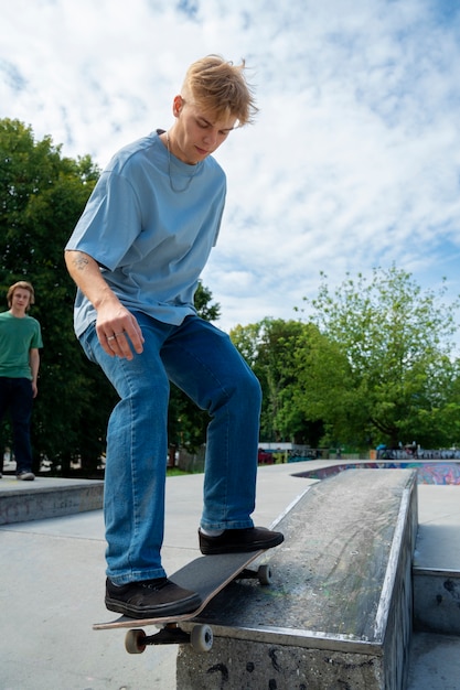 Foto zijaanzicht tiener op skateboard buitenshuis