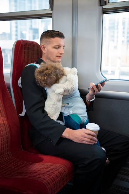 Foto zijaanzicht vader met baby in het openbaar vervoer