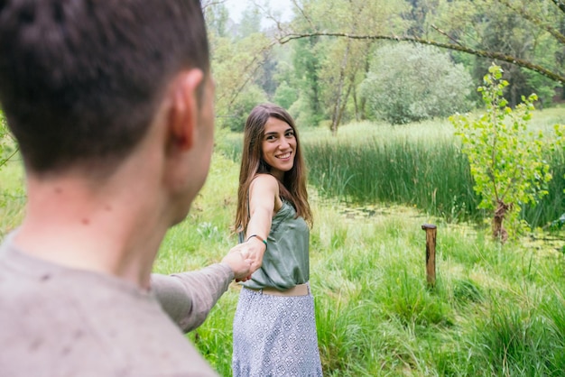 Zijaanzicht van blanke vrouw verliefd sightseeing op het platteland met vriendje. Horizontale weergave van paar verkennen van de natuur met groene meer achtergrond. Mensen en reisconcept.