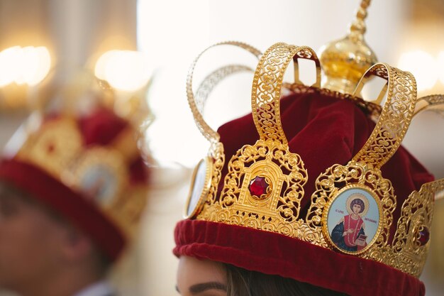 Foto zijaanzicht van bruid en bruidegom man en vrouw wandelen in de orthodoxe christelijke kerk met kronen