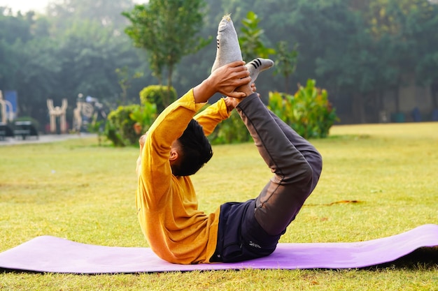 zijaanzicht van de Indiase man die asana's doet in het park