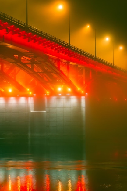 Zijaanzicht van de verlichte brug bij mistig weer Brug in de mist