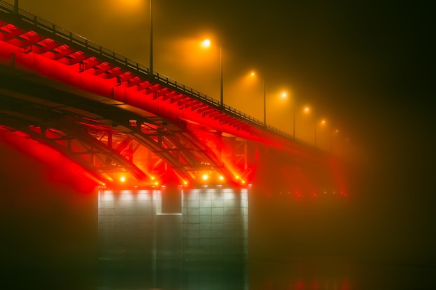 Zijaanzicht van de verlichte brug bij mistig weer Brug in de mist