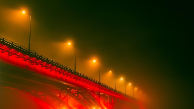 Zijaanzicht van de verlichte brug bij mistig weer Brug in de mist