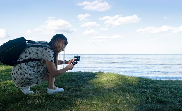 Zijaanzicht van de vrouw die foto met telefoon op de achtergrond van prachtig zeegezicht