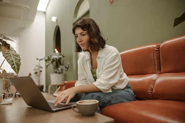 Zijaanzicht van een blanke vrouw die in café zit