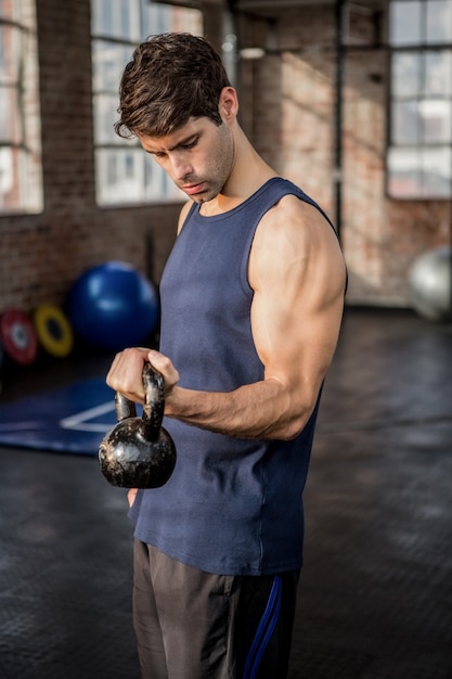 Zijaanzicht van een mens die kettlebell opheft