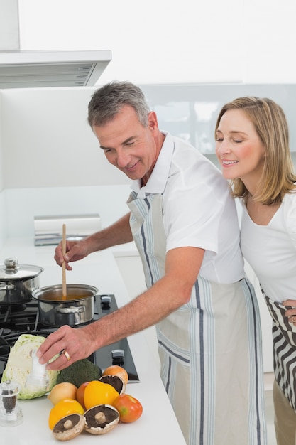 Zijaanzicht van een paar die voedsel in keuken voorbereiden