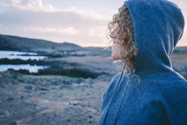 Zijaanzicht van een vrije eenzame vrouw die lacht en geniet van het natuurlandschap in de buitenlucht Concept van mensen in vrijetijdsbesteding buitenshuis Individuele reiziger vrouw Lucht en woestijn op de achtergrond