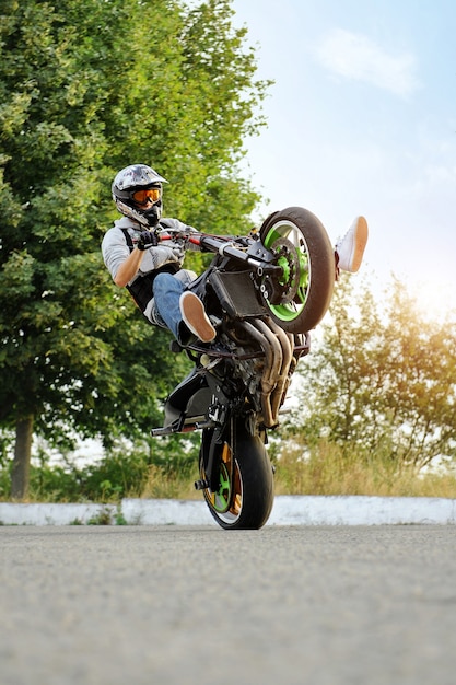 Zijaanzicht van fietser motorrijden op extreme manier.