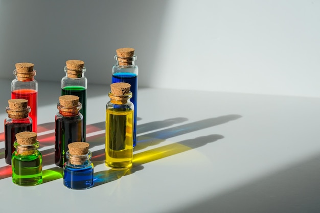 Foto zijaanzicht van flesjes met een substantie van verschillende kleuren. heldere potten op een witte achtergrond.