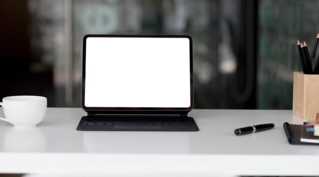 Zijaanzicht van hedendaagse werkplek met laptop computer notebook koffiekopje en briefpapier op houten tablexA