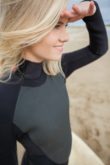Zijaanzicht van mooie blonde afschermingsogen bij strand