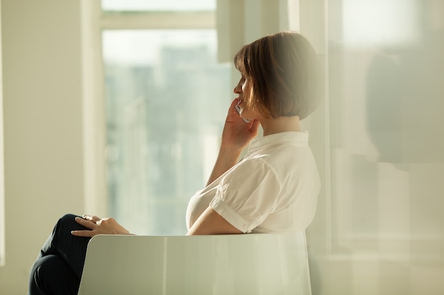 Zijaanzicht van onderneemster die op telefoon spreekt