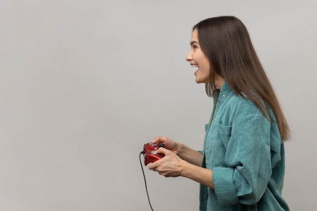 Zijaanzicht van opgewonden vrouw met gamepad winnende videogamescompetitie vooruitkijkend