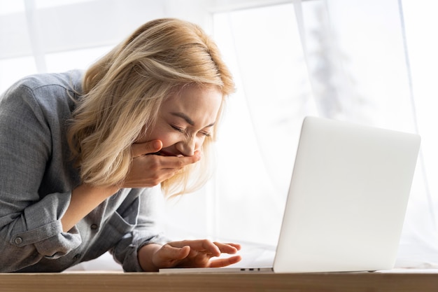 Foto zijaanzicht van smileyvrouw met laptop