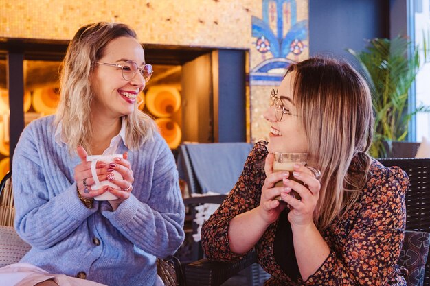 Zijaanzicht van vriendinnen die een middagkoffie hebben bij een Frans restaurant.