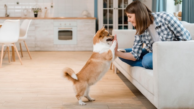 Zijaanzicht van vrouw op laag high-fiving haar hond