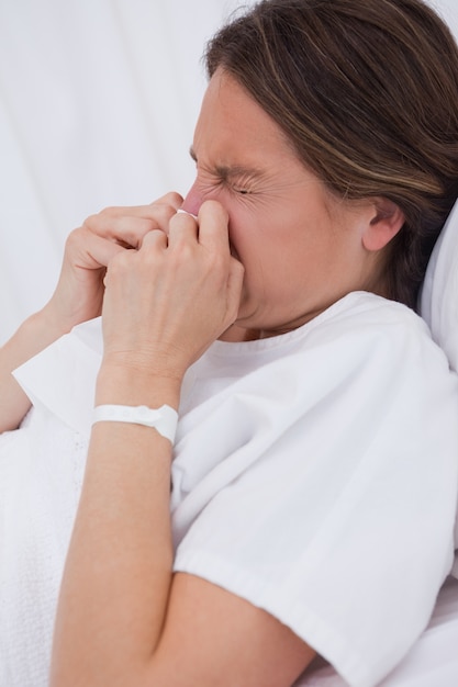 Zijaanzicht van vrouwen in bed het niezen