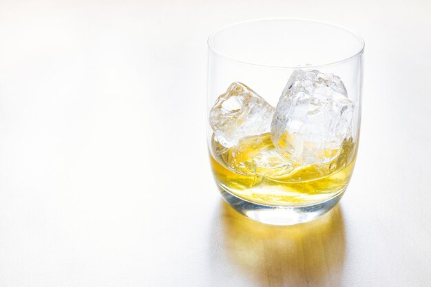 Zijaanzicht van whisky op de rotsen op bleke tafel