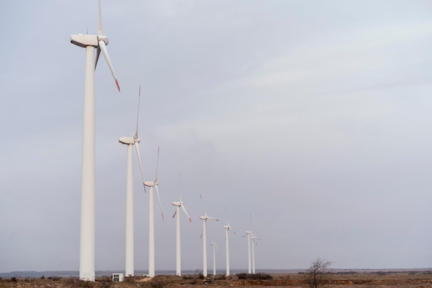 Foto zijaanzicht van windturbines die elektriciteit opwekken in het veld met kopie ruimte