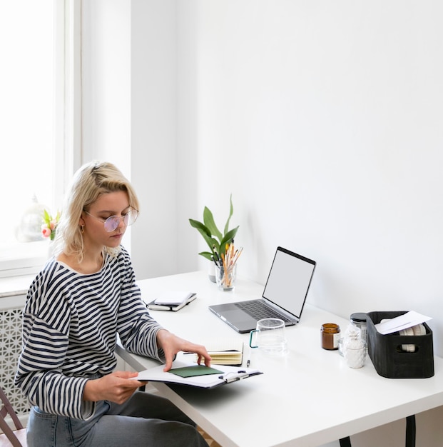 Zijaanzicht vrouw die vanuit huis werkt