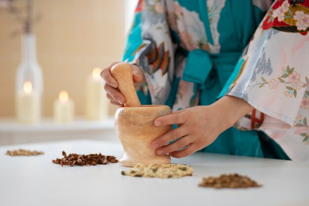 Foto zijaanzicht vrouw met vijzel met stamper