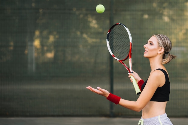 Foto zijaanzicht vrouw tennissen op veld