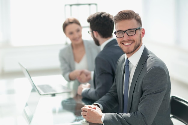 Zijaanzichten succesvolle zakenman zit aan zijn bureaufoto met kopieerruimte