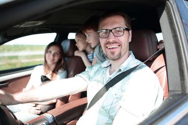 Zijaanzichtgelukkige vader die een auto bestuurt het concept van vrijheid en reizen