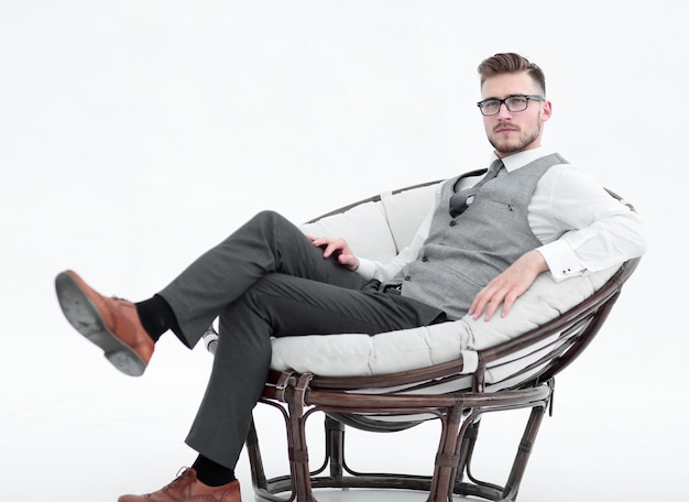 Zijaanzichtmoderne succesvolle man zittend in een ronde stoelfoto met kopieerruimte