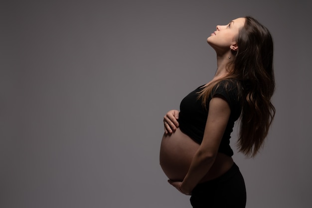 Zijaanzichtportret van de mooie zwangere vrouw