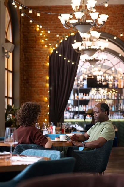 Foto zijaanzichtvrienden die bij restaurant eten